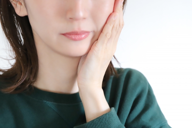 頬に手を添えている若い女性
